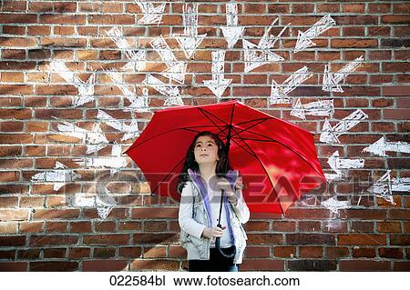 young girl with red umbrella in front of brick wall surrounded by arrows View Large Photo Image Stock Image - young girl with red umbrella in front of brick wall surrounded by arrows. Fotosearch