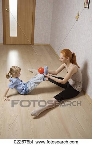 young mother and her daughter doing exercises at home View Large Photo Image Stock Image - young mother and her daughter doing exercises at home. Fotosearch