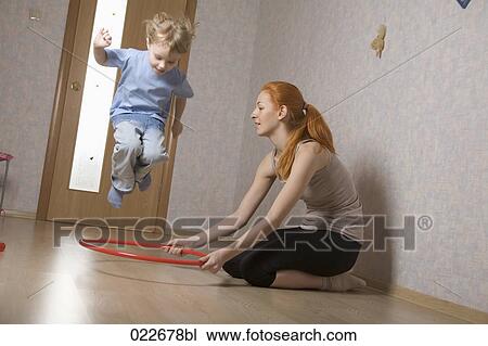 Stock Image - young mother and her daughter doing exercises at home. Fotosearch