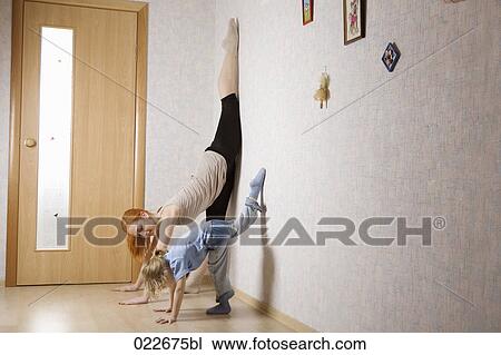 young mother sand daughter doing handstand at home View Large Photo Image Stock Image - young mother sand daughter doing handstand at home. Fotosearch