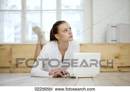 young woman lying on floor working with laptop computer View Large Photo Image Stock Image - young woman lying on floor working with laptop computer. Fotosearch