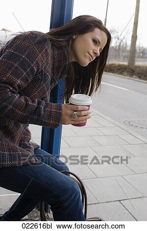 young woman sitting at bus stop waiting View Large Photo Image Stock Image - young woman sitting at bus stop waiting. Fotosearch