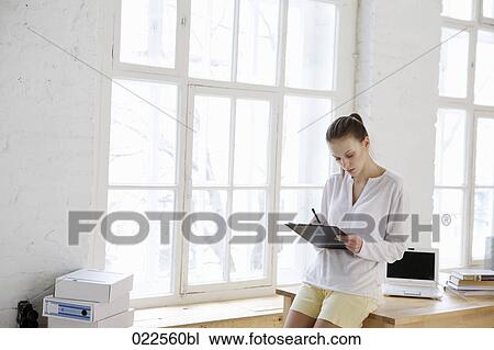 young woman writing on clipboard View Large Photo Image Stock Image - young woman writing on clipboard. Fotosearch