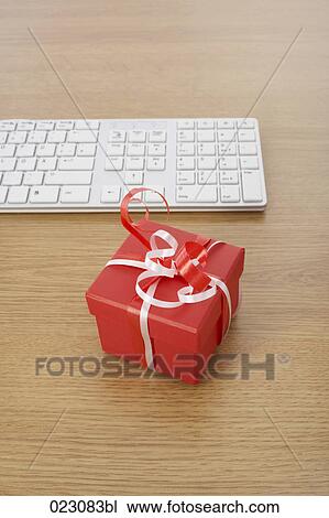 Stock Image - computer keyboard and present on table. Fotosearch