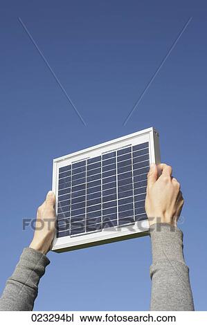 detail of woman holding solar panel up against sky View Large Photo Image Stock Image - detail of woman holding solar panel up against sky. Fotosearch