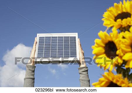 detail of woman holding solar panel up against sky View Large Photo Image Stock Image - detail of woman holding solar panel up against sky. Fotosearch