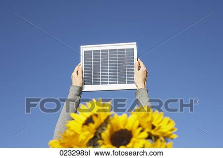 detail of woman holding solar panel up against sky View Large Photo Image Stock Image - detail of woman holding solar panel up against sky. Fotosearch