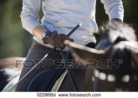 Stock Image - detail of woman on horse. Fotosearch