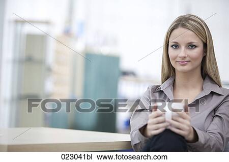 Stock Image - portrait of young businesswoman having coffee break. Fotosearch
