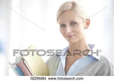 Stock Image - portrait of young businesswoman holding files. Fotosearch