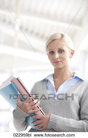 Stock Image - portrait of young businesswoman holding files. Fotosearch