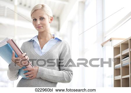 Stock Image - portrait of young businesswoman holding files. Fotosearch