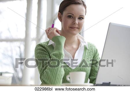 Stock Image - portrait of young businesswoman working with laptop computer. Fotosearch