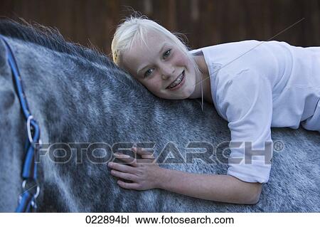 Stock Image - portrait of young girl on white horse. Fotosearch