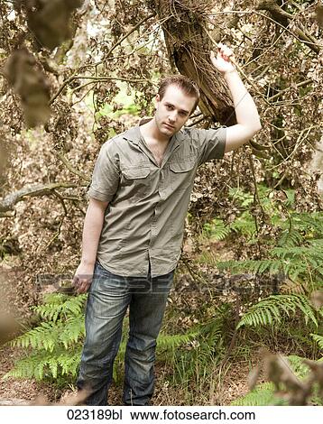 Stock Image - portrait of young man in a forest. Fotosearch