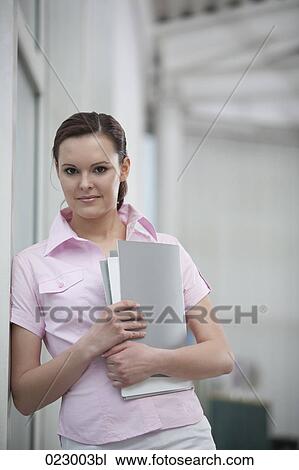 portrait of young woman holding files View Large Photo Image Stock Image - portrait of young woman holding files. Fotosearch