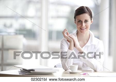portrait of young woman sitting at desk View Large Photo Image Stock Image - portrait of young woman sitting at desk. Fotosearch