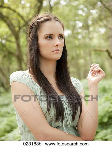 portrait of young woman standing in a forest View Large Photo Image Stock Image - portrait of young woman standing in a forest. Fotosearch