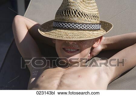 young boy with straw hat relaxing in summer View Large Photo Image Stock Image - young boy with straw hat relaxing in summer. Fotosearch