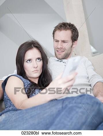 Stock Image - young couple at home watching television. Fotosearch