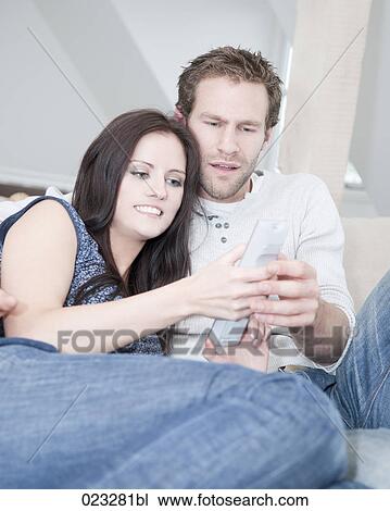 young couple at home watching television View Large Photo Image Stock Image - young couple at home watching television. Fotosearch