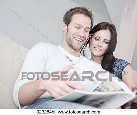 Stock Image - young couple reading magazine together. Fotosearch