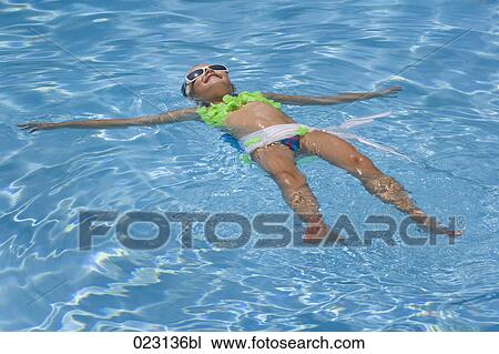 young girl floating in swimming pool View Large Photo Image Stock Image - young girl floating in swimming pool. Fotosearch