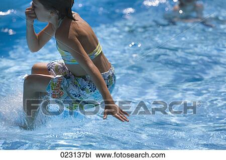 young girl jumping into swimming pool View Large Photo Image Stock Image - young girl jumping into swimming pool. Fotosearch