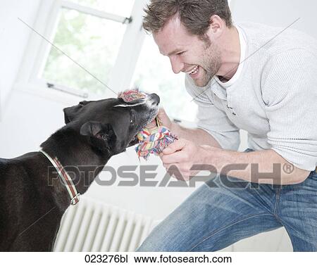 young man and black dog playing View Large Photo Image Stock Image - young man and black dog playing. Fotosearch