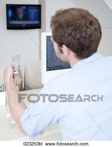 young man at home with remote control watching television View Large Photo Image Stock Image - young man at home with remote control watching television. Fotosearch