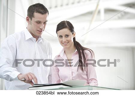 businessman and female colleague discussing file View Large Photo Image Stock Image - businessman and female colleague discussing file. Fotosearch