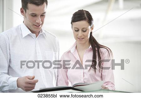 businessman and female colleague discussing file View Large Photo Image Stock Image - businessman and female colleague discussing file. Fotosearch