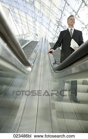 businessman standing on escalator View Large Photo Image Stock Image - businessman standing on escalator. Fotosearch