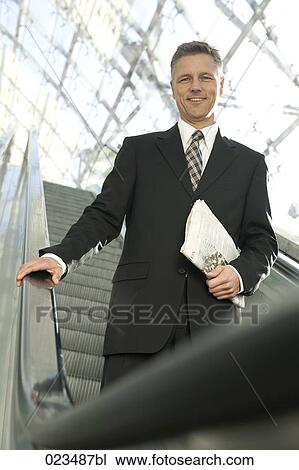 businessman standing on escalator View Large Photo Image Stock Image - businessman standing on escalator. Fotosearch