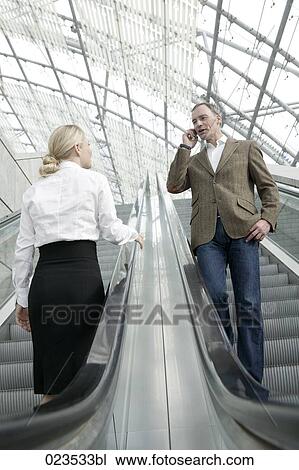 businesswoman and man meeting on escalator View Large Photo Image Stock Image - businesswoman and man meeting on escalator. Fotosearch