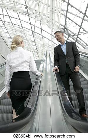 businesswoman and man meeting on escalator View Large Photo Image Stock Image - businesswoman and man meeting on escalator. Fotosearch