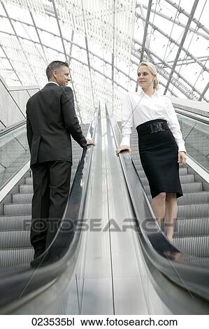 businesswoman and man meeting on escalator View Large Photo Image Stock Image - businesswoman and man meeting on escalator. Fotosearch