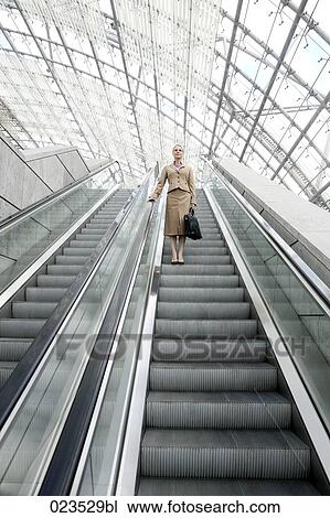 businesswoman on escalator View Large Photo Image Stock Image - businesswoman on escalator. Fotosearch