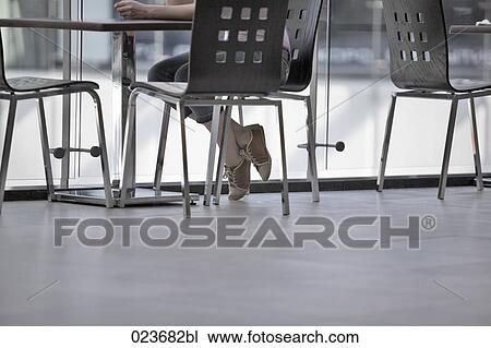 Stock Image - detail of young woman sitting in canteen. Fotosearch