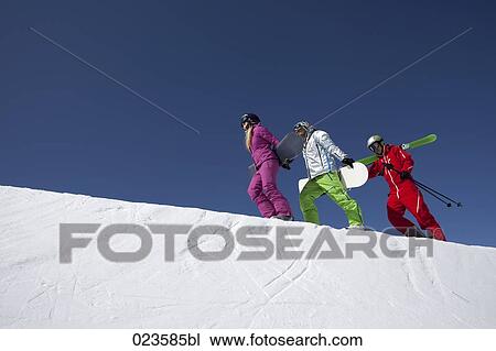group of three people with skis and snowboards walking up mountain View Large Photo Image Stock Image - group of three people with skis and snowboards walking up mountain. Fotosearch