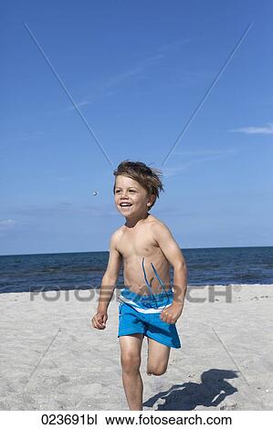Stock Image - little boy running on beach. Fotosearch