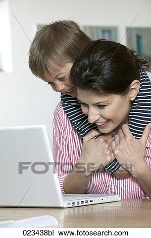 mother and young son at table in fron of laptop computer View Large Photo Image Stock Image - mother and young son at table in fron of laptop computer. Fotosearch