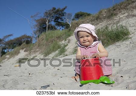 portrait of baby girl playing in sand on beach View Large Photo Image Stock Image - portrait of baby girl playing in sand on beach. Fotosearch