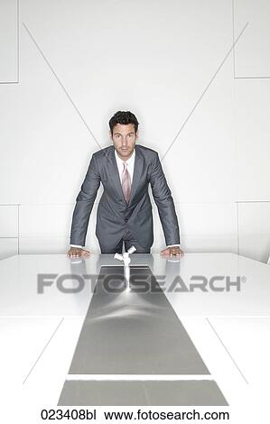 Stock Image - portrait of businessman behind table in meeting room. Fotosearch