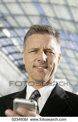 Stock Image - portrait of businessman with mobile phone. Fotosearch