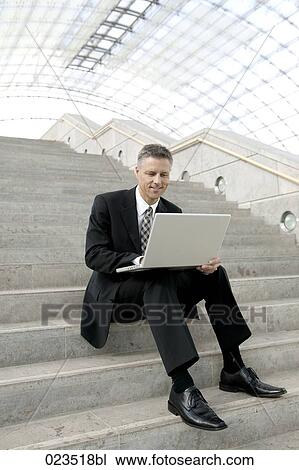 Stock Image - portrait of businessman working with laptop computer. Fotosearch