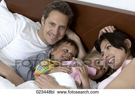 portrait of family lying in bed together View Large Photo Image Stock Image - portrait of family lying in bed together. Fotosearch