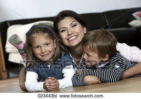 portrait of mother and young children lying on floor at home View Large Photo Image Stock Image - portrait of mother and young children lying on floor at home. Fotosearch