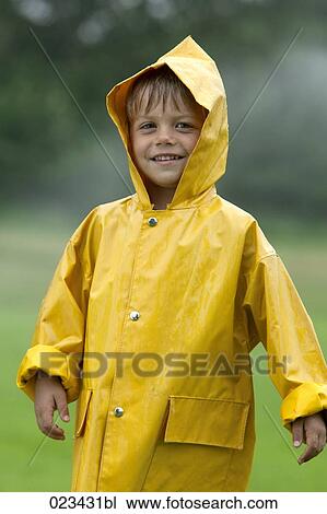 Stock Image - portrait of young boy wearing yellow raincoat. Fotosearch