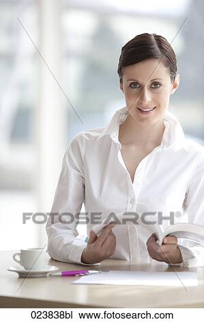 portrait of young businesswoman sitting at table View Large Photo Image Stock Image - portrait of young businesswoman sitting at table. Fotosearch